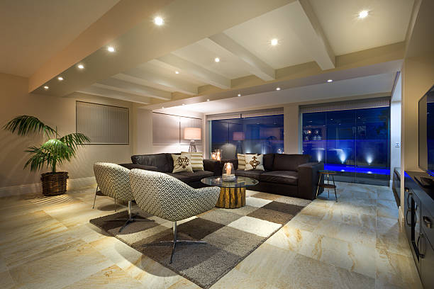 luxurious living room with big windows, couple of sofas and armchairs